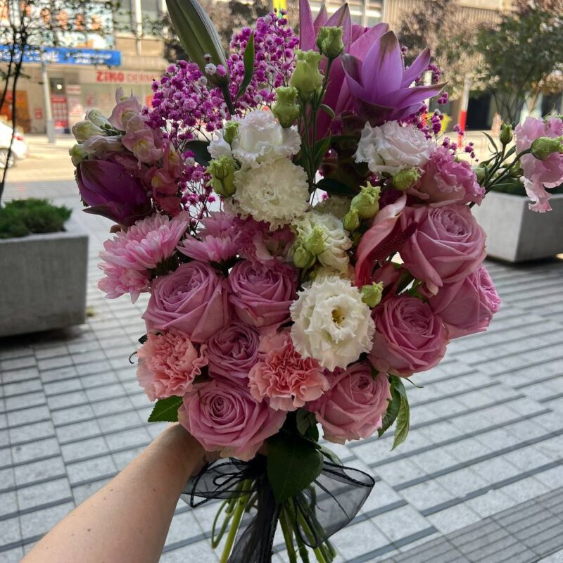 Wiązanka pogrzebowa w odcieniach różu z eleganckimi dodatkami kwiatowymi.