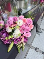 Wiązanka pogrzebowa w odcieniach różu z eleganckimi dodatkami kwiatowymi.